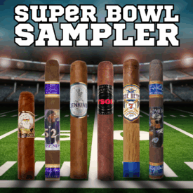 Super Bowl Sampler promotional image featuring six premium cigars standing upright on a football field inside a stadium, with bold Super Bowl Sampler text above and athlete branded cigar bands visible across the lineup