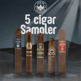 Five Joya de Nicaragua cigars standing upright on a dark stage with a spotlight. From left to right: Joya Black, Rosalones Reserva, Antaño Dark Corojo, Antaño Gran Consul, and Joya Red. Above the cigars is the Joya de Nicaragua logo with text that reads “5 Cigar Sampler.”